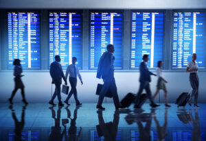 Varias personas caminando rápidamente frente a pantallas de datos, representando cómo las aerolíneas pueden aprovechar la analítica avanzada para detectar oportunidades invisibles a simple vista.